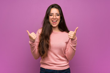 Wall Mural - teenager girl over purple wall with thumbs up gesture and smiling