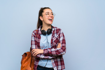 Teenager student girl over isolated blue wall happy and smiling