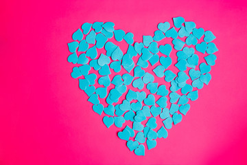  Flat lay of blue heart on bright pink background with copy space, top view. Valentine's Day. Symbol of love.
