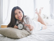 © Sataporn - Close up of a happy young woman smile while lying on the bed at home on morning.