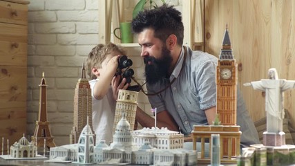 Wall Mural - Ready to big travel. Little child and man with binocular and miniature architecture. Boy son and father with world landmark buildings in miniature. Discovering new places. Looking for adventure.