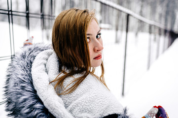 Wall Mural - the girl beside the fence of metal bars amid winter forest