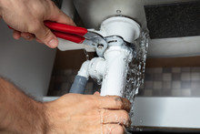 Plumber Fixing Sink Pipe With Adjustable Wrench