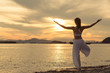 © I'm Thongchai - Rearview of woman practicing yoga. standing near sea. doing Tree Pose/Vrikshasana.  .beautiful landscape view sky on morning and enjoying sea view, concept for exercising, health care