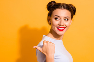 Canvas Print - Close up portrait of carefree funky isolated childish lady pointing with her thumb dressed in white sweater over yellow background