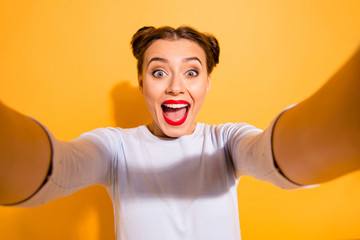Wall Mural - Close up photo of cute funny cheerful shocked childish lady taking photos impressed by incredible news with positive mood has her mouth open dressed in white sweater isolated over yellow background 