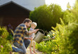 © Maria Sbytova - Middle age man and his little son watering flowers in the garden at summer sunny day