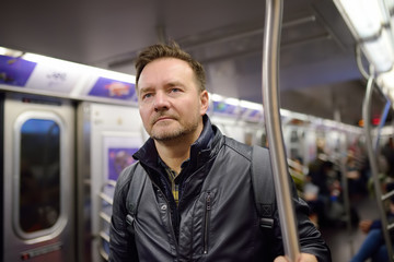 Mature man looks out the window of the car in the subway in new York.