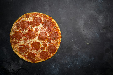 Italian pizza pepperoni on dark stone background