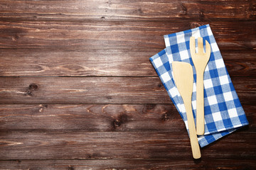 Wall Mural - Wooden cutlery with blue napkin on brown table