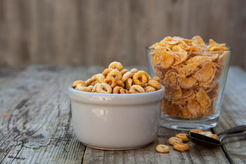 Wall Mural - Bowl with corn rings an flakes, cereals breakfast. rustic textured background. Healthy food for kids. Copy space.