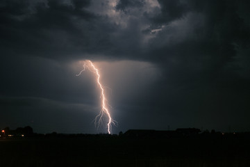 Bright branched lightning strike near an electricity mast from a severe thunderstorm in The Netherlands