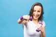 © denis_vermenko - Sporty woman doing boxing exercises, making direct hit with dumbbells. Photo of muscular female wearing sportswear on blue background. Strength and motivation.