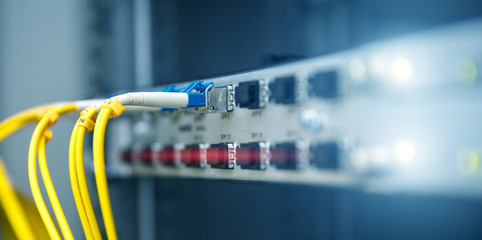 Technology banner. Close up fiber optic cable. Servers racks. Severs computer in a rack at the large data center. Photo contains noise