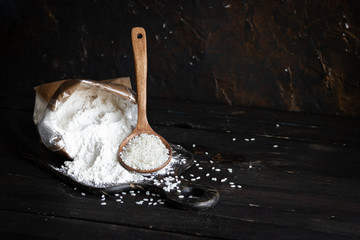 White rice flour in a crafting bag on a dark wooden background