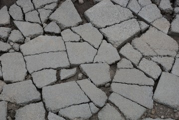 Wall Mural - gray stone background of pieces of asphalt with cracks on the road