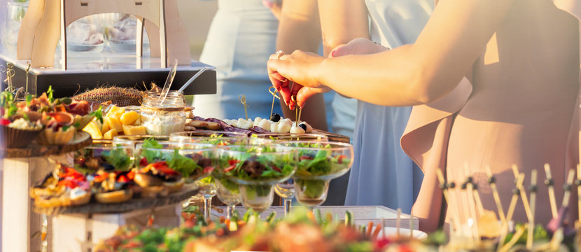 beautifully decorated catering banquet table with different food snacks and appetizers with sandwich
