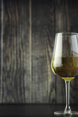 Wall Mural - Transparent bottle of white dry wine on the table. White wine glass on a wooden background.
