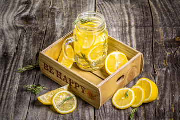 Health care, fitness, healthy nutrition diet concept. Fresh cool lemon infused water, cocktail, detox drink, lemonade in a glass jar on a wooden background. copy space