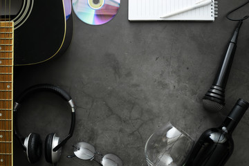 Wall Mural - Guitar and accessories on a stone background. Desk musician, headphones, microphone.