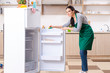 © Elnur - Young woman cleaning fridge in hygiene concept