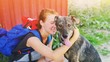 © raisondtre - Portrait young hipster woman with backpack kissing dog outdoors Funny pet and attractive girl playing fun Positive human emotions, facial expression, feelings Friendship hug between owner and animal