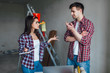 © Тарас Нагирняк - Renovation, conflict,, people and emotions concept - Young woman and man with arguing during renovation in apartment while serach new things !