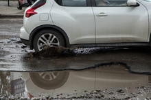 Car Tyre About To Pass Through Large Pothole Full Of Water