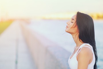 Side view profile portrait of a happy brunette woman relaxing breathing fresh air outdoors in summer Girl close eyes doing deep breath exercises. Positive emotion success, peace of mind, zen concept.