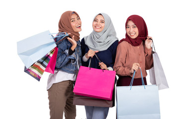 portrait of three muslim woman with shopping bag isolated over white background