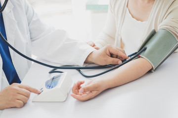 The doctor measures blood pressure to the patient