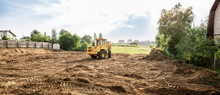 Large Yellow Wheel Loader Aligns A Piece Of Land For A New Building, Wih Copy Space, Banner