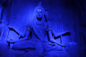 Wall Mural - Mesmerising sculpture of Lord Shiva meditating in a blue light during Ganpati Festival, Pune.