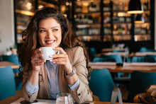 Young Woman Is Drinking Coffee In A Cafe