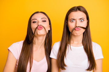Wall Mural - Close up photo two people beautiful she her ladies models send air kisses playing curls make fake moustache crazy facial expression wear white pink casual t-shirts isolated yellow background