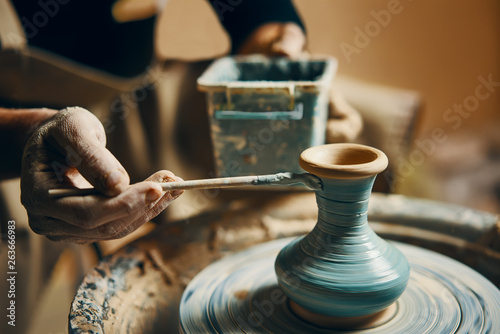 Cuadros en Lienzo Man painting handmade pottery at ceramic workshop