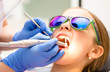 © Dmitry Naumov - Preteen girl receiving teeth cleaning procedure in pediatric dental clinic