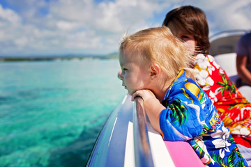 Canvas Print - Happy beautiful fashion family, children and parents, dressed in hawaiian shirts, enjoying day trip with speed boat