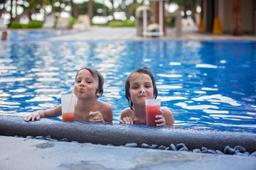 Canvas Print - Cute boys, drinking cocktail in pool while on holiday on tropical island