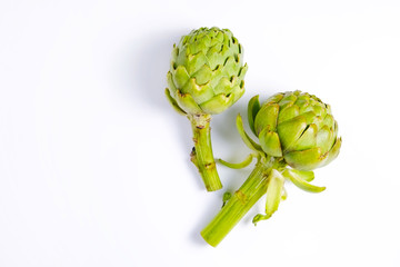 Fresh green Italian Artichoke isolated on white background. Organic local produce vegetable. Vegan diet. Clean eating concept. Close up, top view, flat lay.