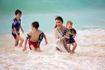 Canvas Print - Mother and child playing at tropical beach. Family sea summer vacation. Mom and kid, toddler boy, play in the water. Ocean and water fun for parent and kids