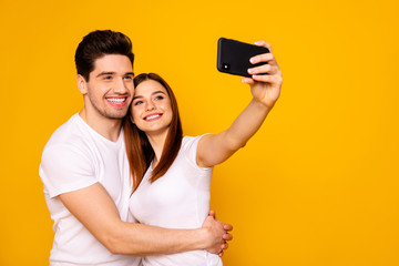 Portrait of his he her she two nice attractive lovely cheerful cheery positive people making taking selfie enjoying free time isolated over vivid shine bright yellow background