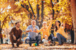 © Mediteraneo - Multl generation family in autumn park having fun