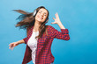 © denis_vermenko - Woman with headphones listening music. Music teenager girl dancing against isolated blue background.