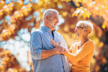 Wall Mural - Active seniors on a walk in autumn forest