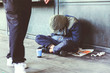 © FollowTheFlow - Homeless adult man sitting on the street in the shadow of the building and begging for help and money. Problems of big modern cities. Indifference of people. Social issues.