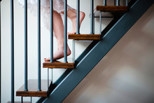 Woman In A Beautiful Lace Nightgown Walking Downstairs In The Morning At Home. Close Up Woman Feet On Stairs.