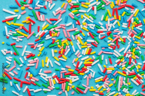 top view of colorful sprinkles over blue background, festive decoration for V...