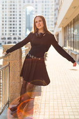 Outdoor portrait of young teenager brunette girl with long hair. girl on city in black dress