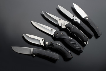 Wall Mural - folding knives on a black background. pen knives on a dark background